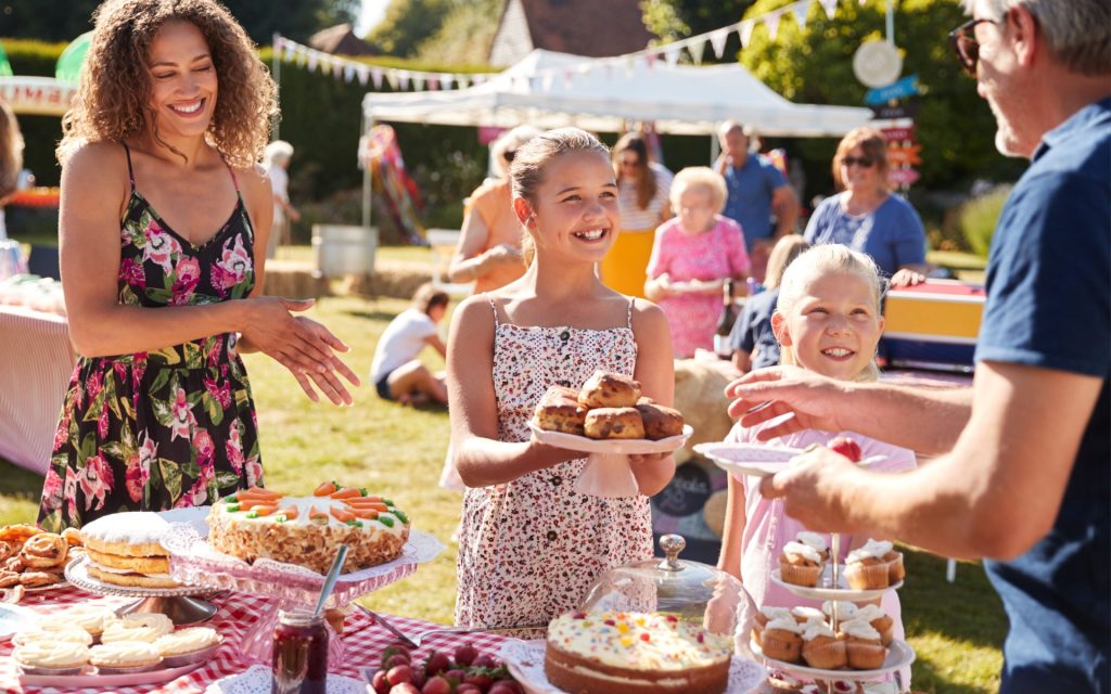 Collecting payments with Cheddar Up and the MoneyMinder Store. Volunteers running a bake sale offer a plate of pastries to a donor.