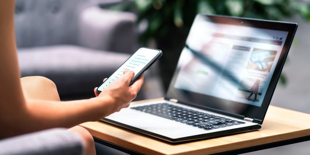 Wireless wifi for remote work in airport lounge bar, hotel lobby or cafe. Phone and laptop. Woman using smartphone and modern notebook pc computer on table. Real estate agent or student reading email.